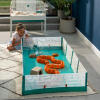 A child looking at a hamster playing in the playpen