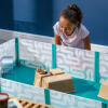 A child watching a hamster playing in a playpen