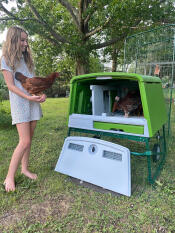 A woman holding a chicken.