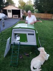 Man with dog and Omlet Green Eglu Cube Large Chicken Coop and Run