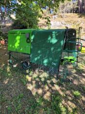 Green Eglu Cube chicken coop with heavy duty cover attached to the Cube run.