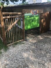 Green Eglu Cube chicken coop inside a wooden pen.