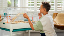 young boy opening the wide door of the Omlet hamster cage