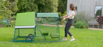 A woman moving an Eglu Go Up chicken coop