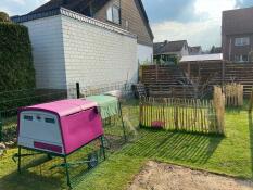 A cube chicken hutch in a garden