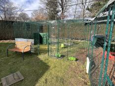 Two Walk In Chicken runs connected together in a garden.