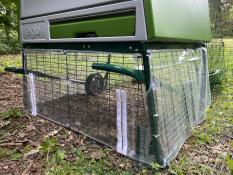 Clear wind covers installed at the bottom of a green chicken coop