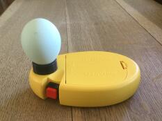 an egg lamp with an egg balanced in it on top of a table