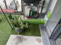 Green Zippi Tunnel with Hutch to Run Connection Kit, connecting an outdoor rabbit run to the inside of a house.