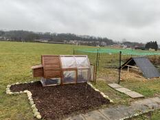 a large setup for chickens with a chicken coop and a run attached