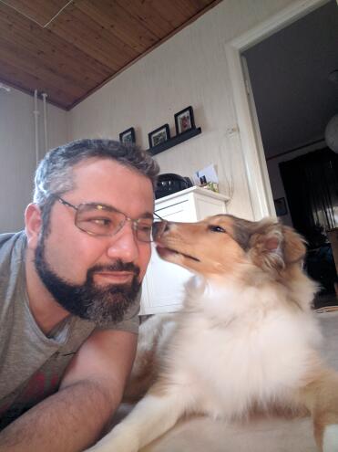 Dog giving man kisses